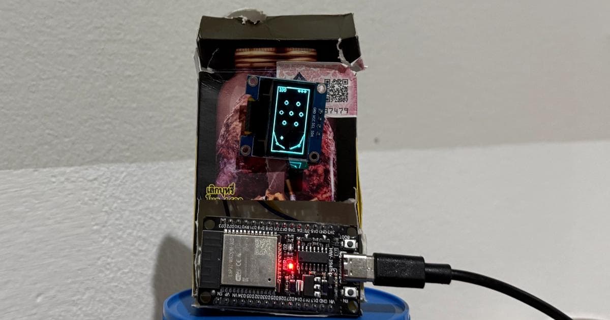 ESP32 pinball game running on a tiny OLED display, housed inside a cigarette case with the board and USB cable visible