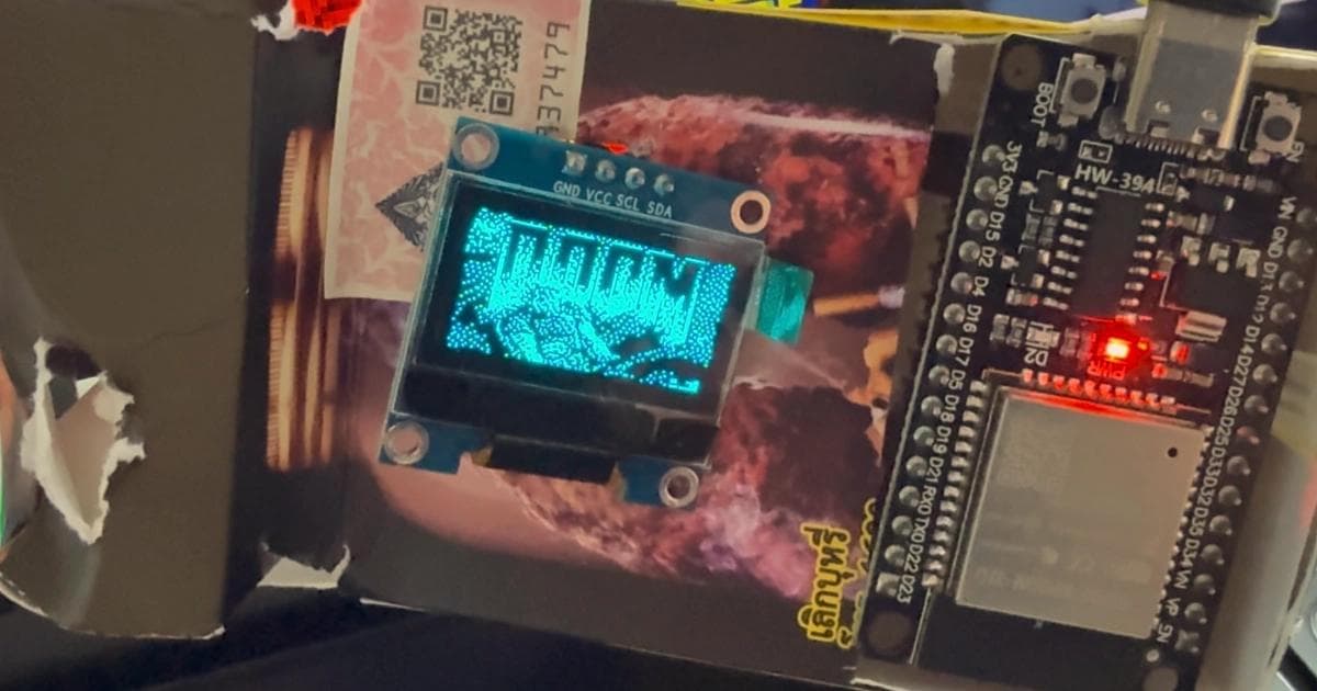 Doom title screen dithered to 1-bit and displayed on a 128x64 SSD1306 OLED connected to an ESP32 DevKit, mounted inside a cardboard enclosure