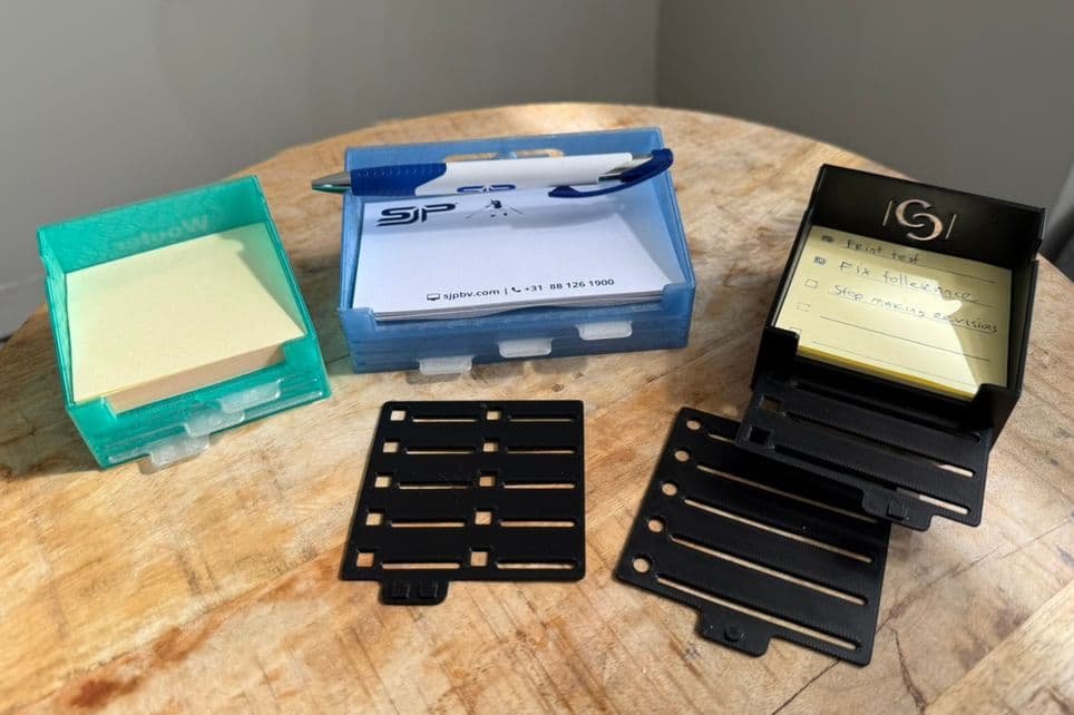 Three finished parametric 3D printed note holders in different sizes, with removable stencil sheets, note blocks and an integrated pen holder.